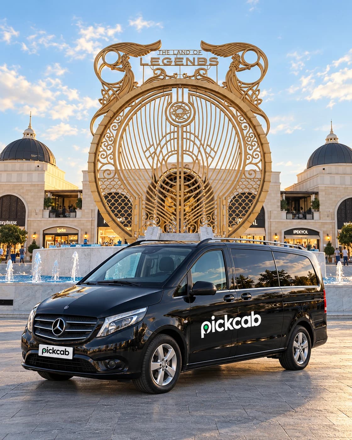 The Land of Legends'ın büyük işlemeli kapısı önünde, gövdesinde ve plakasında Pickcab logosu bulunan siyah transfer aracını gösteren temsili görsel